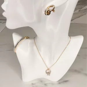 Parure de bijoux en acier inoxydable doré avec collier ajustable, boucles d'oreilles rondes et bracelet scintillant.